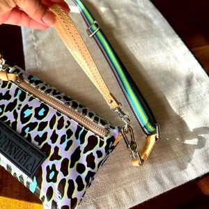 Folded Consuela crossbody, light purple background with print.